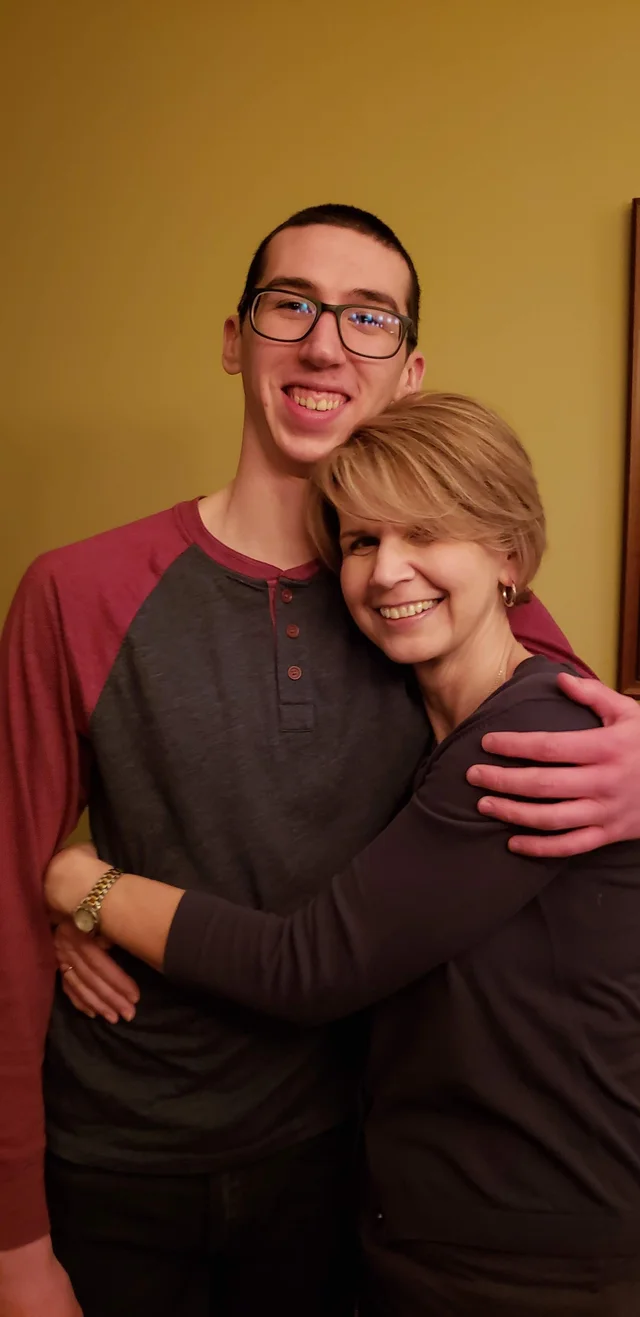 Alex embracing a family member